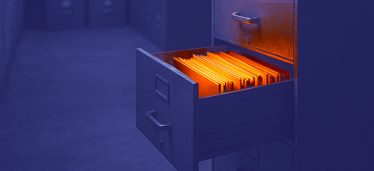 Die Schublade eines Aktenschranks ist geöffnet, die darin enthaltenen Akten leuchten orange