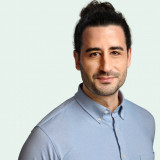 Zu sehen: Ein Portrait von Orkan Özdemir in einem hellblauen Hemd