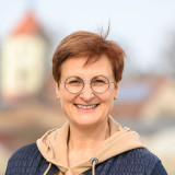 Annett Klingsporn, lebensfrohe Frau mit Brille vor der Kirche meines Heimatortes - Porträtfoto