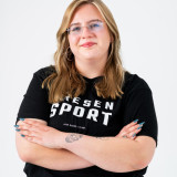 Bild von Lisa Pfitzmann mit verschränkten Armen, lächelnd