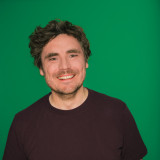 Sebastian lächelt der Hintergrund ist grün.