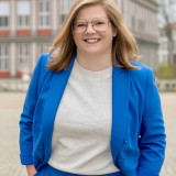 Lena Krause Bild der Kandidatin Lena Krause in einem blauen Blazer und weißem Pulli vor dem Wolfenbütteler Schloss.