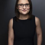 Profilbild der SPD-Landtagskandidatin Sandra Göbel. Sie hat schulterlanges braunes Haar und trägt eine schwarze Brille mit goldenen Verzierungen. 