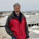 Strand an der Ostsee, Buhnen ins Meer, Mann in lässiger Haltung