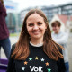 Carina Beckmann lächelt optimistisch in die Kamera, denn Sie will in den Bundestag. Im Hintergrund hilft ihr das Team.