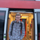 Das Bild zeigt Martin Neuner, wie er lachend aus einem Regionalzug aussteigt.