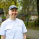 Willi steht vor einer Brücke mit einer blauen Schirmütze und weissem Tshirt