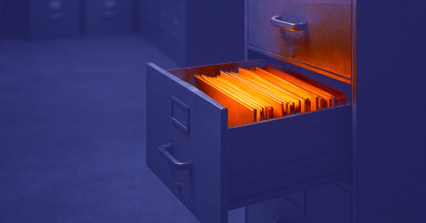 Die Schublade eines Aktenschranks ist geöffnet, die darin enthaltenen Akten leuchten orange